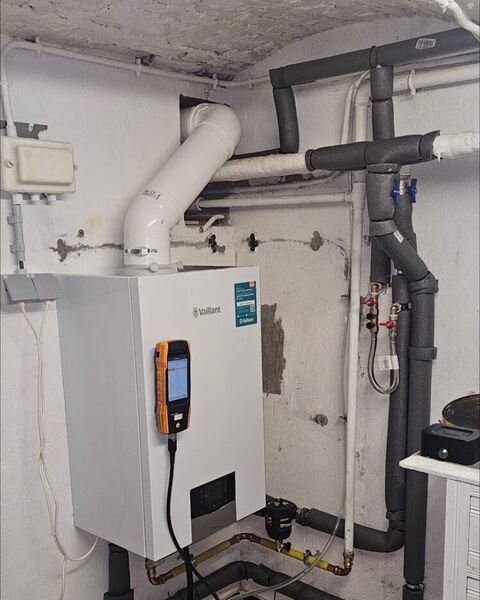 Appareil de mesure fixé sur une chaudière murale Vaillant, pendant un contrôle.